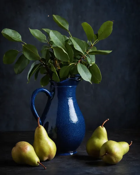 Four pears and a blue pitcher with green leaves on a dark surface.